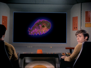 Chekov in front of the viewscreen, which displays the amoeba.