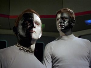 The two-tone assholes facing the camera, one side of their faces white and the other side black. Different sides, being the message.