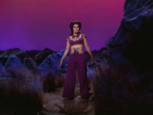 Losira's outfit, full-body. Pants, a weird belly-button cover, and All of the Purple.