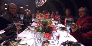 The Klingon delegation and the senior staff of the Enterprise face each other awkwardly across a banquet table.
